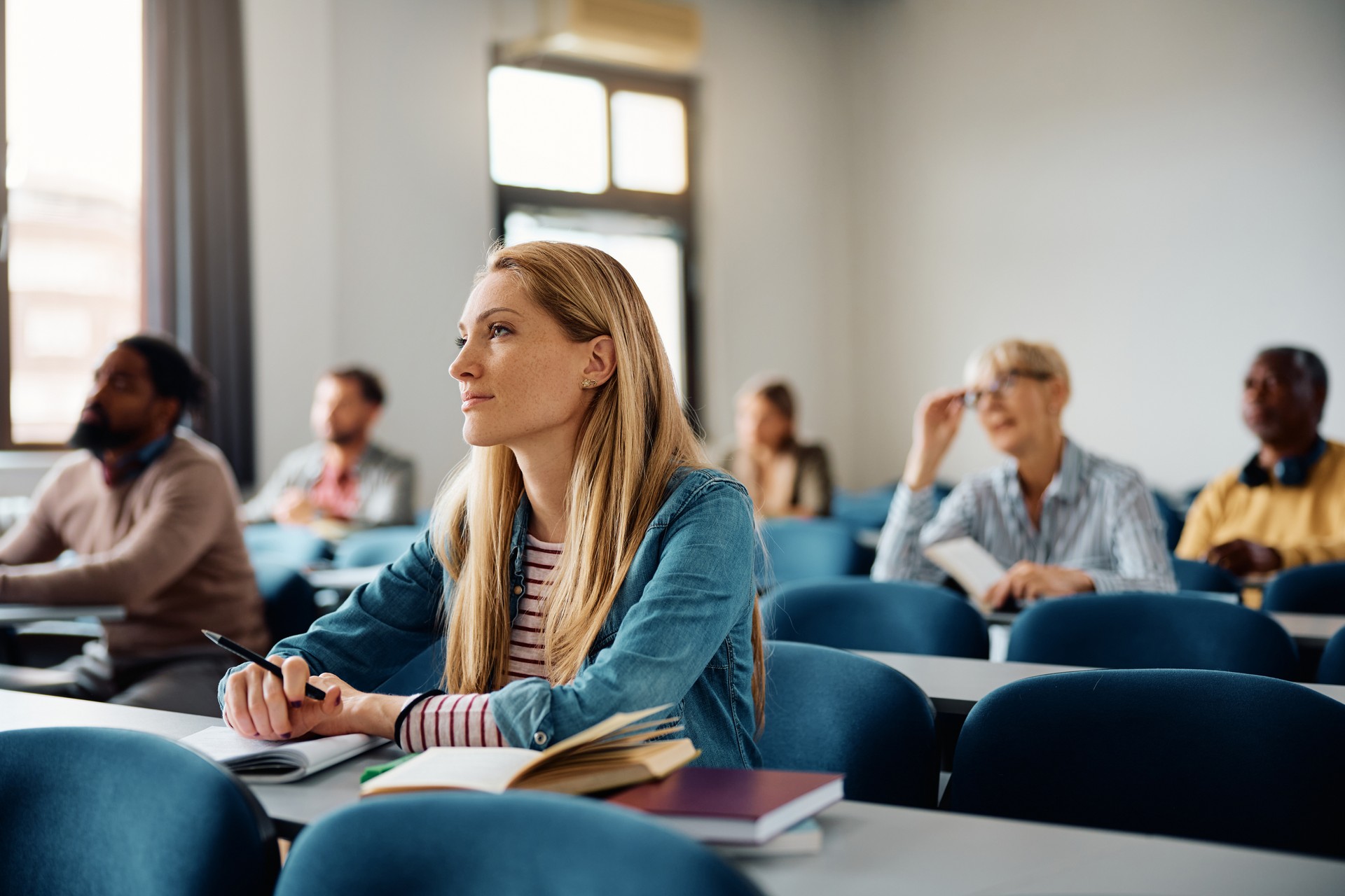 Mid adult woman paying attention during a class in lecture hall.